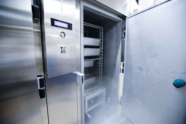 Stainless steel blast chiller with door ajar allowing condensed water vapor to exit the freezer chamber