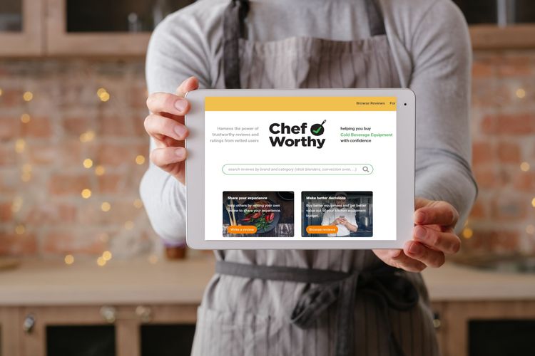 Chef holding a digital tablet in front of themselves showing the ChefWorthy Home Page