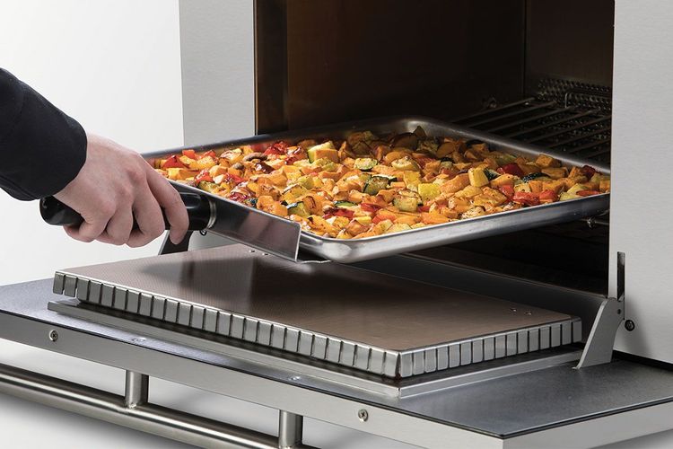 Chef removing vegetables on a square pan from a high speed oven